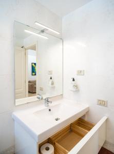 Baño blanco con lavabo y espejo en Villas Las Almenas, en Maspalomas