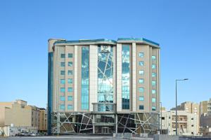 Un palazzo alto con un orologio sulla parte anteriore di Green Park Hotel a Doha