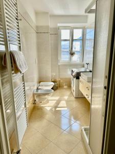 Baño blanco con aseo y lavamanos en Val di Non Apartment en Cles