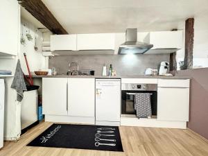 een keuken met witte apparatuur en een zwart tapijt op de vloer bij Duplex Cosy 85 m2 hyper centre Châlons-en-Champagne in Châlons-en-Champagne