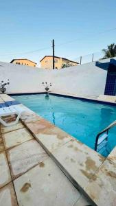 a swimming pool with a chair next to a building at Oásis da Praia in Caucaia