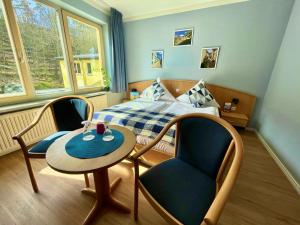 a bedroom with a bed and a table and chairs at Family Club Harz in Quedlinburg