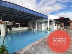 a large swimming pool in front of a building at MATIINJANNAH HOMESTAY Alor Setar in Alor Setar