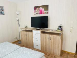 ein Schlafzimmer mit einem TV auf einem Holzständer mit einem Bett in der Unterkunft Privatunterkunft mit Bad und Küche in Seenähe in Zülpich
