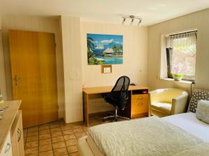 - une chambre avec un bureau, un lit et une chaise dans l'établissement Privatunterkunft mit Bad und Küche in Seenähe, à Zülpich