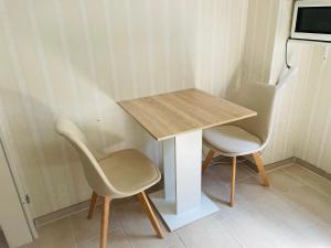 einen Tisch und zwei Stühle neben einem Tisch in der Unterkunft Privatunterkunft mit Bad und Küche in Seenähe in Zülpich