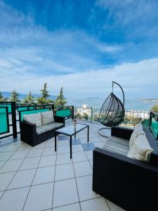 un patio avec des canapés et une table sur le toit dans l'établissement Rezidenca Panorama Apartments, à Vlorë