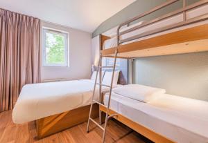 two bunk beds in a room with a window at B&B HOTEL Colmar Vignobles Ouest in Wintzenheim