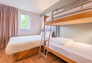 2 Etagenbetten in einem Zimmer mit Fenster in der Unterkunft B&B HOTEL Colmar Vignobles Ouest in Wintzenheim