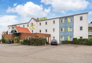 ein Hotel mit einem Auto auf einem Parkplatz in der Unterkunft B&B HOTEL Colmar Vignobles Ouest in Wintzenheim