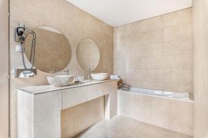 a bathroom with a tub and a sink and a mirror at Hôtel Terminus in Grenoble