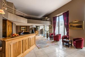 a living room with a bar and red chairs at Hôtel Terminus in Grenoble