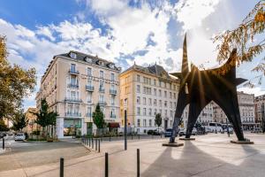 a statue in the middle of a city with buildings at Hôtel Terminus in Grenoble +20 photos