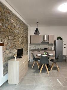 a kitchen with a table and chairs and a stone wall at Casa vacanze Savà in Lagaro