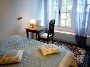 a bedroom with a bed and a table and a window at MANOIR DU TERTRE au coeur de la forêt de Brocéliande in Paimpont +50 photos