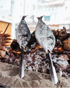 Tres peces están cocinando en la parte superior de una parrilla en Estudio ROMÁNTICO La Carihuela, en Torremolinos