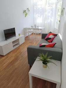 sala de estar con sofá, TV y mesa en Sant Jordi Pisos - Consell de Cent en Barcelona