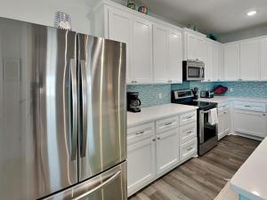 eine Küche mit weißen Schränken und einem Edelstahlkühlschrank in der Unterkunft Mambos Grill in Rockport + 20 Fotos