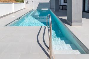 a swimming pool with a metal handrail next to a house at Villa Martin in Nerja