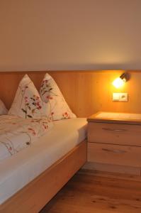 ein Schlafzimmer mit einem Bett mit Kissen und einem Nachttisch in der Unterkunft Speckign in Steinhaus