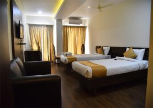 Siddipet的住宿－Swarna Palace，酒店客房,配有两张床和椅子