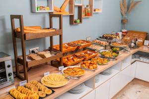 uma linha de buffet com diferentes tipos de pão e pastelaria em Family Aparthotel em Casablanca