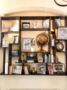 a book shelf with books and a globe on it at Explorer Hostel & Apartment Stare Miasto OLD TOWN 24H in Poznań