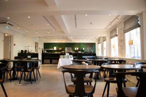 a restaurant with tables and chairs in a room at Gentofte Hotel in Gentofte