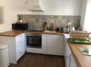 a kitchen with white cabinets and a stove top oven at Charmante maison proche de la mer in Saint-Pol-de-Léon