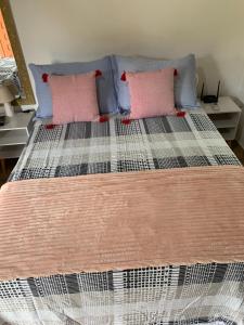 a bed with two pink pillows on top of it at Chalé Topázio no Recanto Diamantina entre Palmeiras e Capão in Palmeiras +76 photos