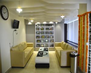 Siddipet的住宿－Swarna Palace，客厅配有两张沙发和一个炉灶
