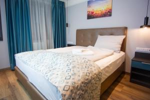 1 dormitorio con 1 cama grande y cortinas azules en ASD Hotel en Filderstadt
