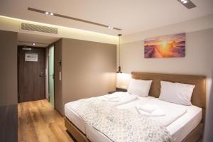 a bedroom with a large bed with white sheets at ASD Hotel in Filderstadt