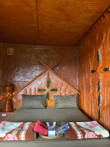 a bedroom with a bed in a wooden room at Akha Mud House Mae Salong in Mae Salong