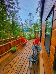 a wooden deck with red chairs and a table at Cliffside Hideaways 