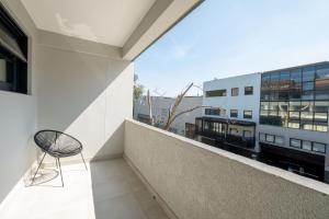 a chair sitting on the balcony of a building at Inn & Out Plus Rosebank in Johannesburg