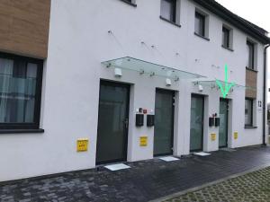 a row of doors on a white building at Apartament Zielony 12/2 in Starogard Gdański