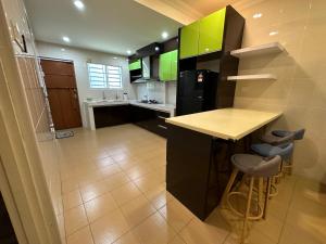 a kitchen with green cabinets and a black refrigerator at Claire Home Stay in Ipoh