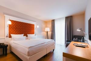 ein Hotelzimmer mit einem großen Bett und einem Schreibtisch in der Unterkunft Berggasthof Königstuhl in Heidelberg