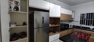 uma cozinha com um frigorífico de aço inoxidável e armários brancos em Recanto da Luz de Órion em Pedra Bela