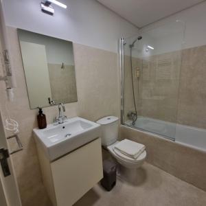 ein Bad mit einem WC, einem Waschbecken und einer Dusche in der Unterkunft Neo Porto in Porto