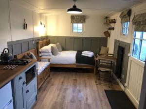 a small bedroom with a bed and a kitchen at Clay Bank Huts, Roseberry Shepherds Hut in Ingleby