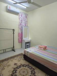 a bedroom with a bed and a tv in it at Wafiy Homestay in Machang
