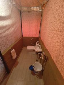 a small bathroom with a toilet and a sink at TENTFORTABLE Village Retreat in Agra