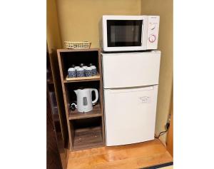 a microwave sitting on top of a refrigerator at Guest House -KiSARA- - Vacation STAY 98548v in Shimada