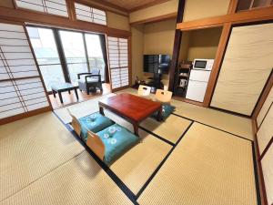 a living room with a wooden table and blue chairs at Guest House -KiSARA- - Vacation STAY 98548v in Shimada