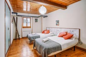Habitación con 2 camas, techo de madera y suelo de madera. en Casa Rural ARIX en Sallent de Gállego