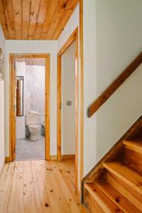 pasillo con suelo de madera y baño con aseo en Casa Rural ARIX en Sallent de Gállego