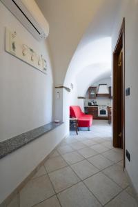 um corredor que leva a uma sala de estar com um sofá vermelho em Agriturismo del Ponte "pomelo" em Rialto