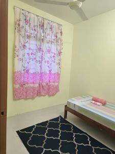 Habitación con cama, ventana y alfombra. en Wafiy Homestay en Macang